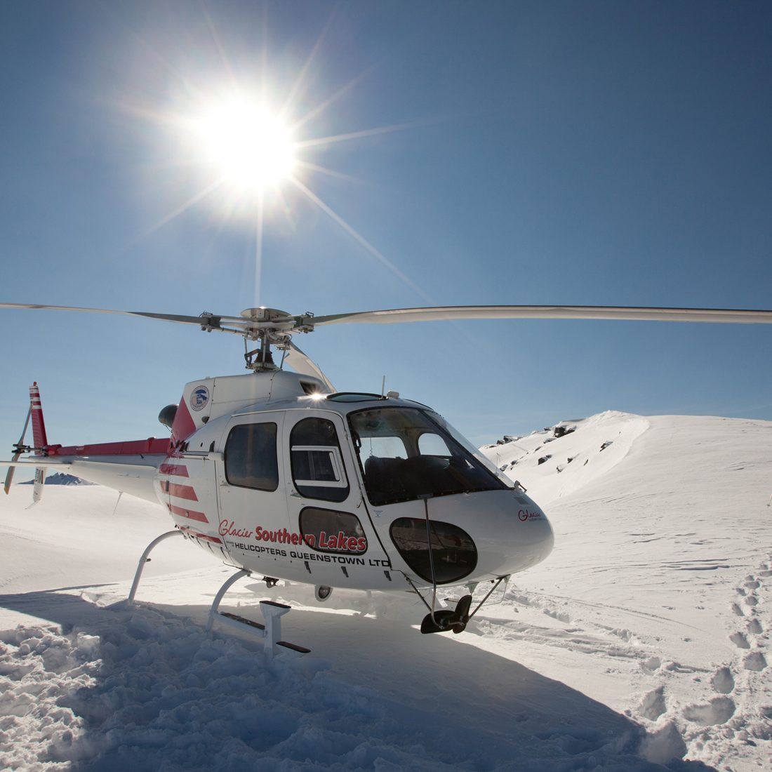 "Wanaka, New Zealand - August 23rd, 2012: Photo of helicopter taking off on mountain ridge whilst heliskiing with Southern Lakes Heliski, Wanaka, New Zealand."