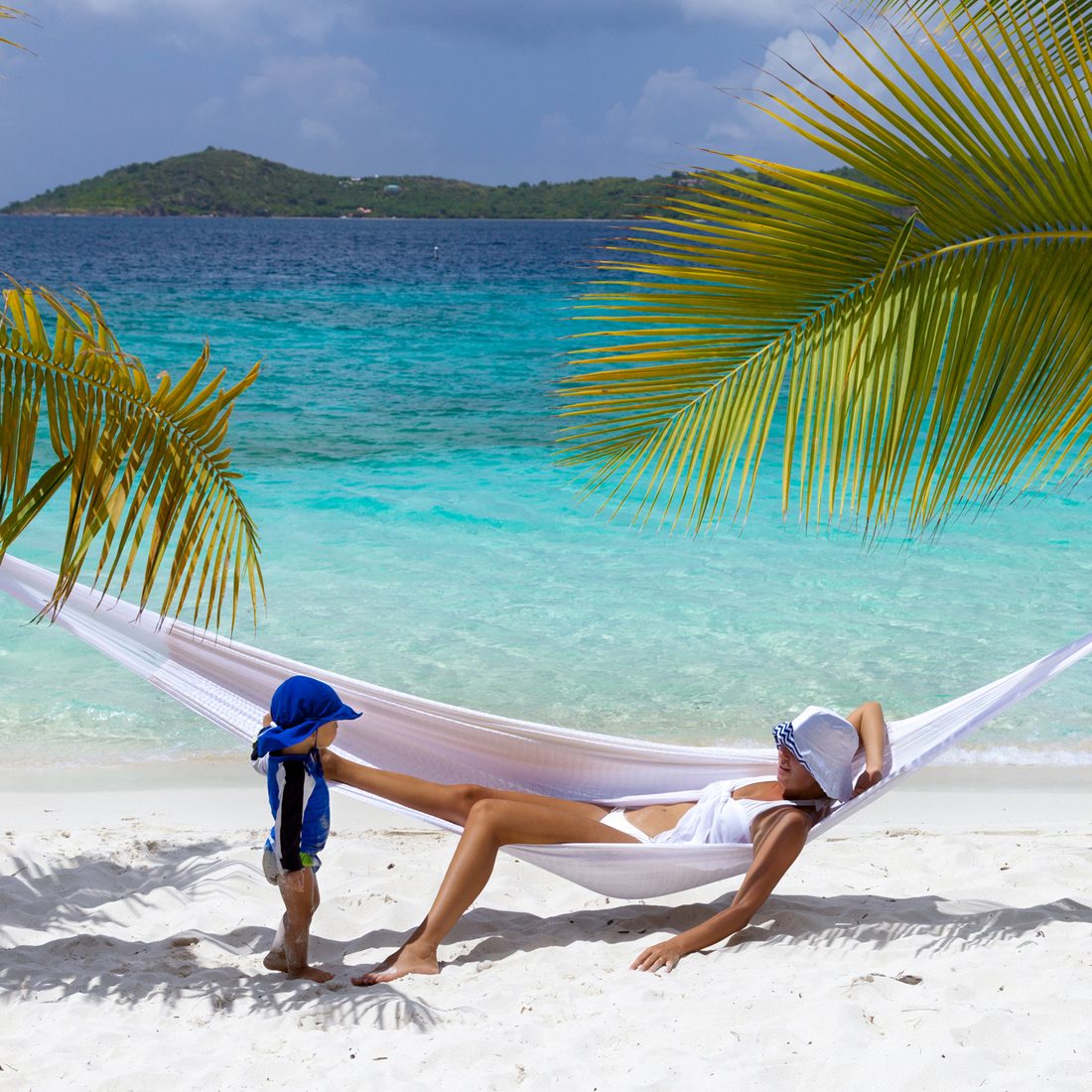 mother and child relaxing in hammock on tropical beach in the Caribbean